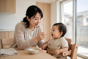 赤ちゃんに離乳食を食べさせる母親