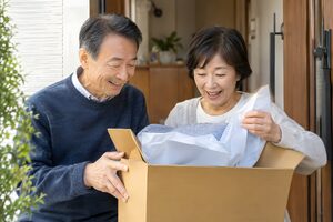 届いた優待品を開ける60代夫婦