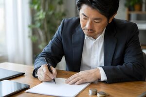 書類に署名する40代男性