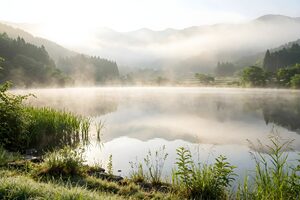 朝もやが立ちこめる山あいの湖