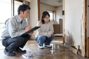 被害を調べる保険の担当者と住人