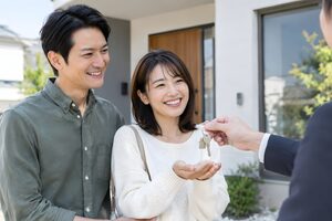 新居の前で鍵を受け取る夫婦