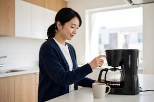 キッチンでコーヒーを淹れて一息つく女性