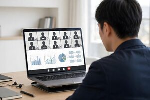 資料を共有しながらオンライン会議に出る男性
