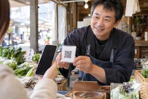 屋台でコードを見せる店主