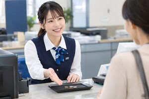 窓口で接客する20代の銀行員