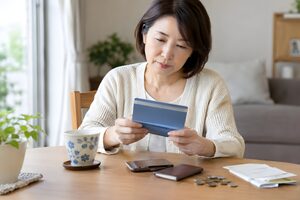 自宅で通帳を確認する50代女性