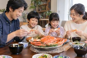 返礼品のカニを囲む家族の食卓