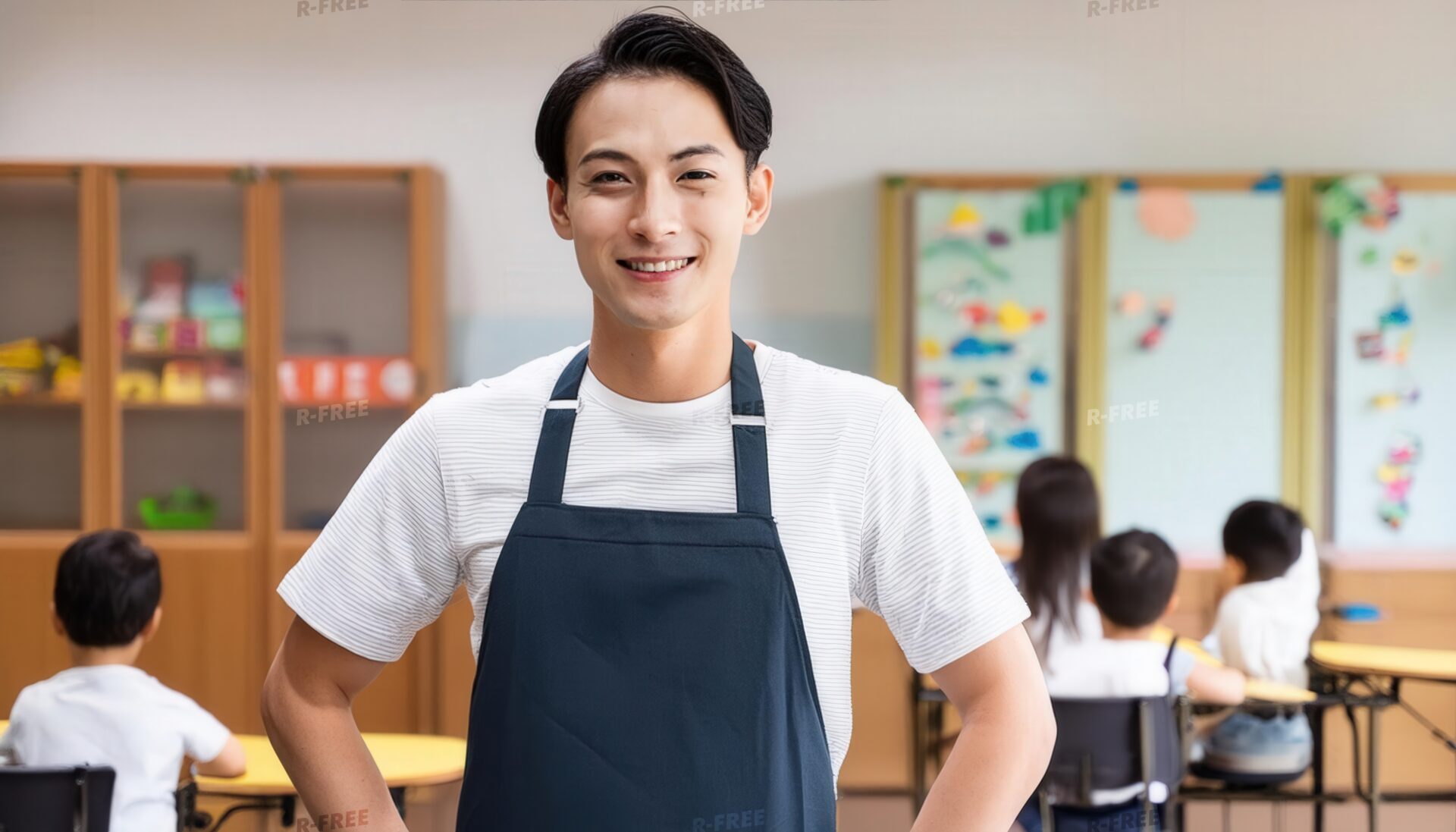 笑顔の男性保育士と教室で遊ぶ子どもたち