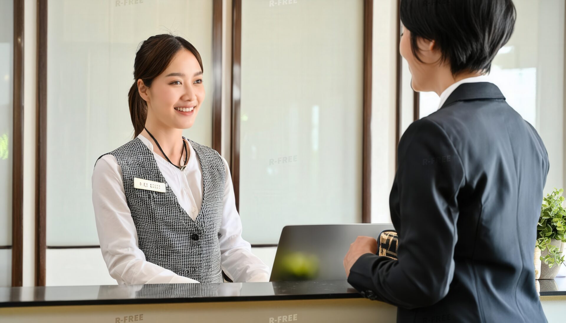 ホテルの受付でゲストに対応する女性スタッフ