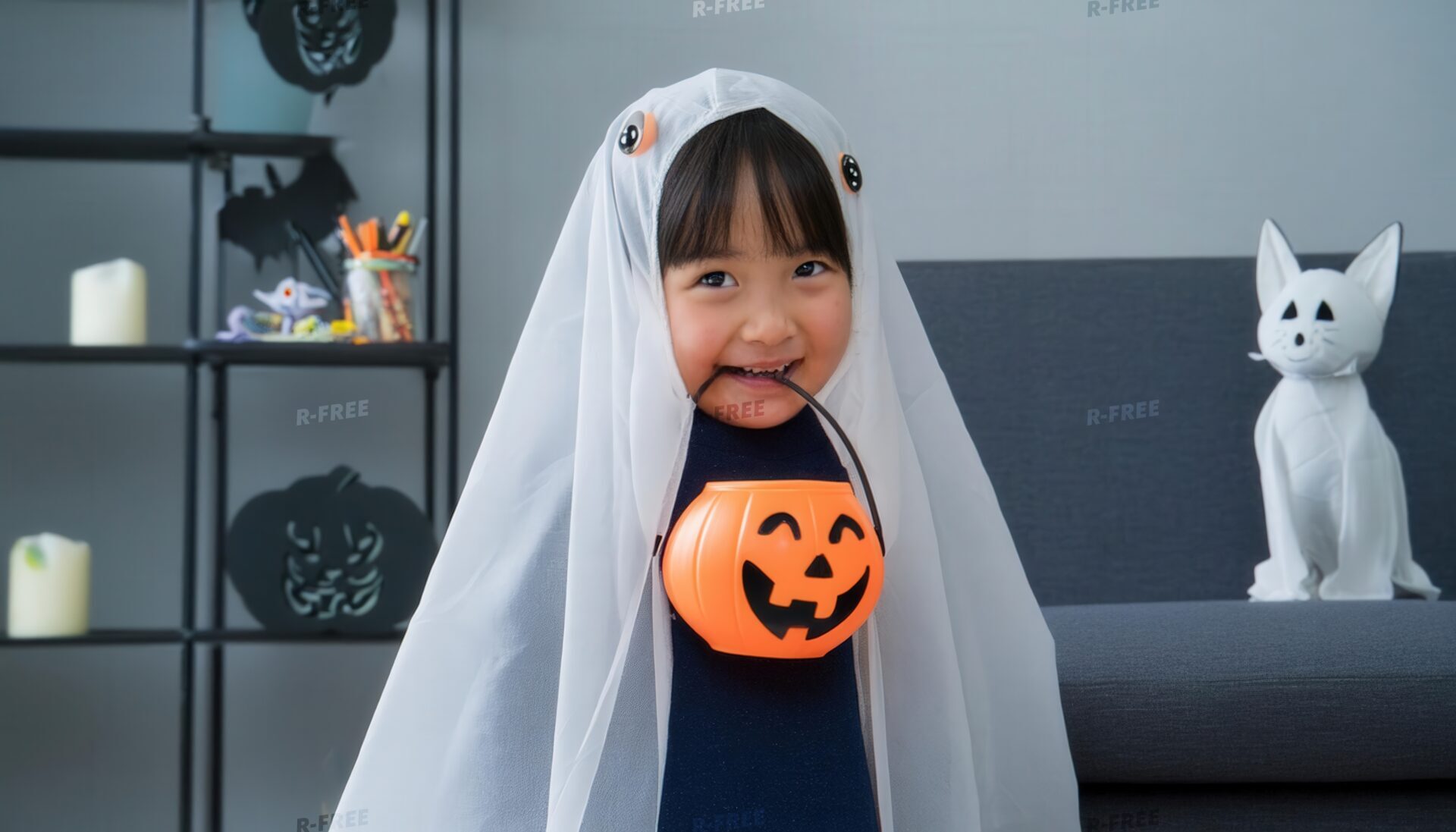 パンプキンバケツを持つゴーストの仮装の子供