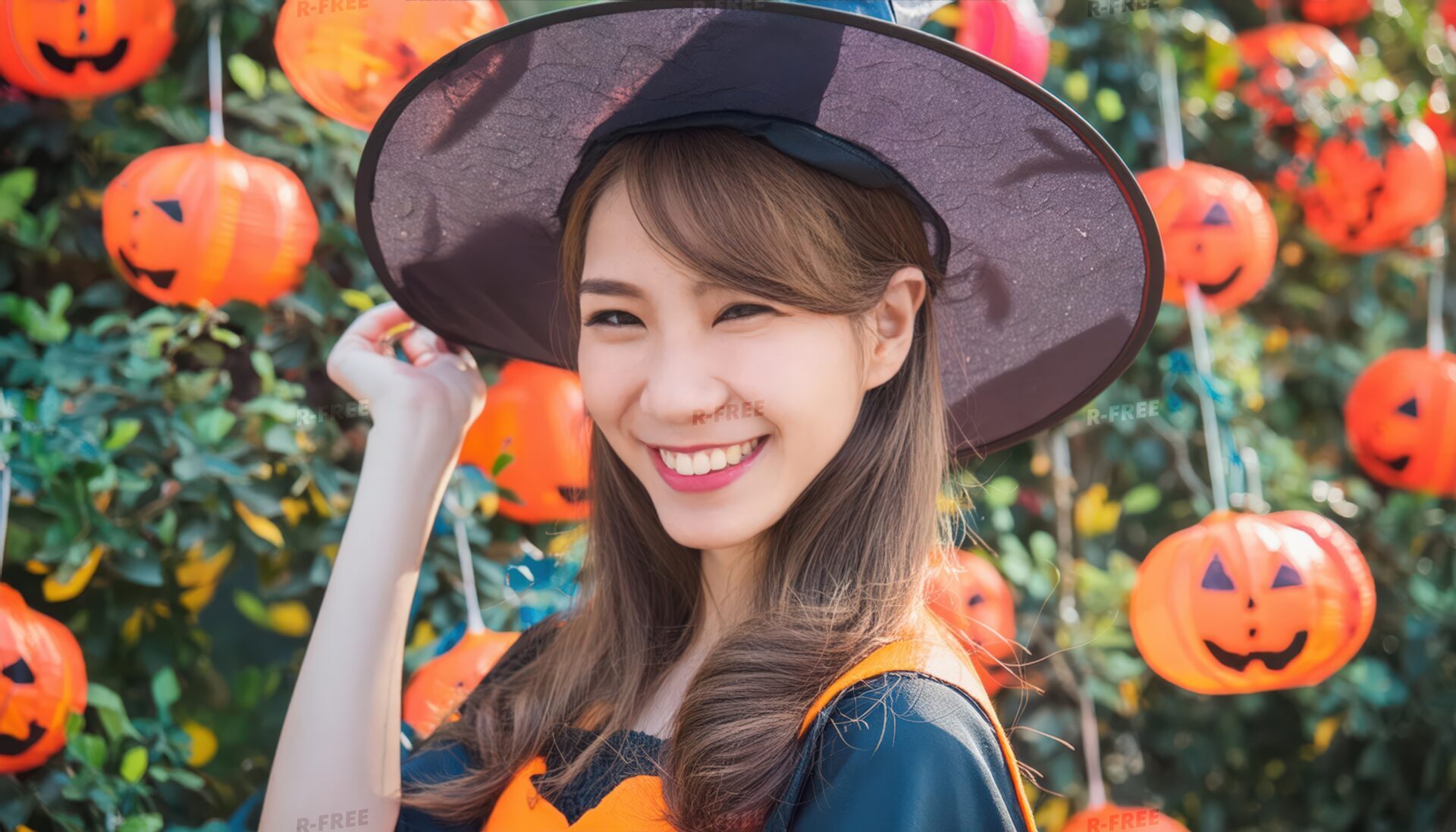 ハロウィンランタンと魔女仮装の女性