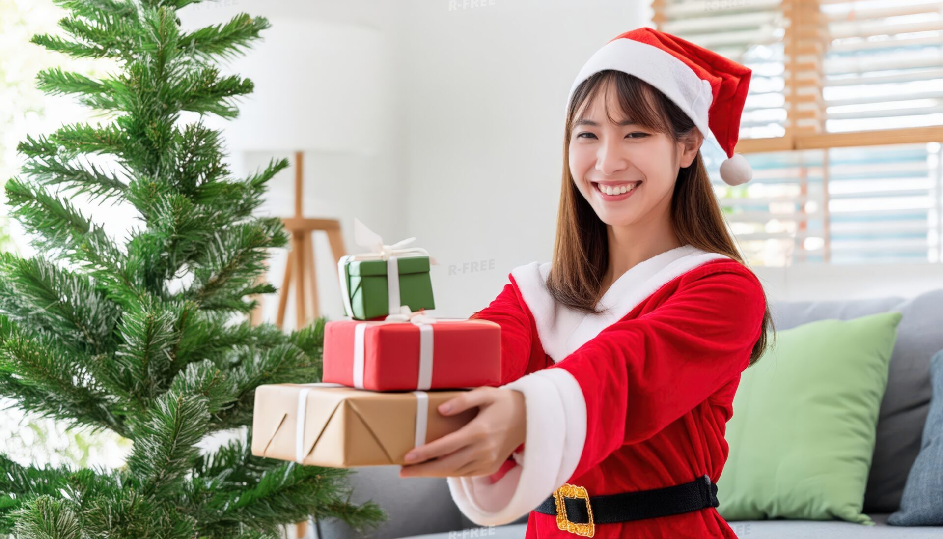 サンタ衣装を着た女性がプレゼントを渡す（クリスマスツリー）