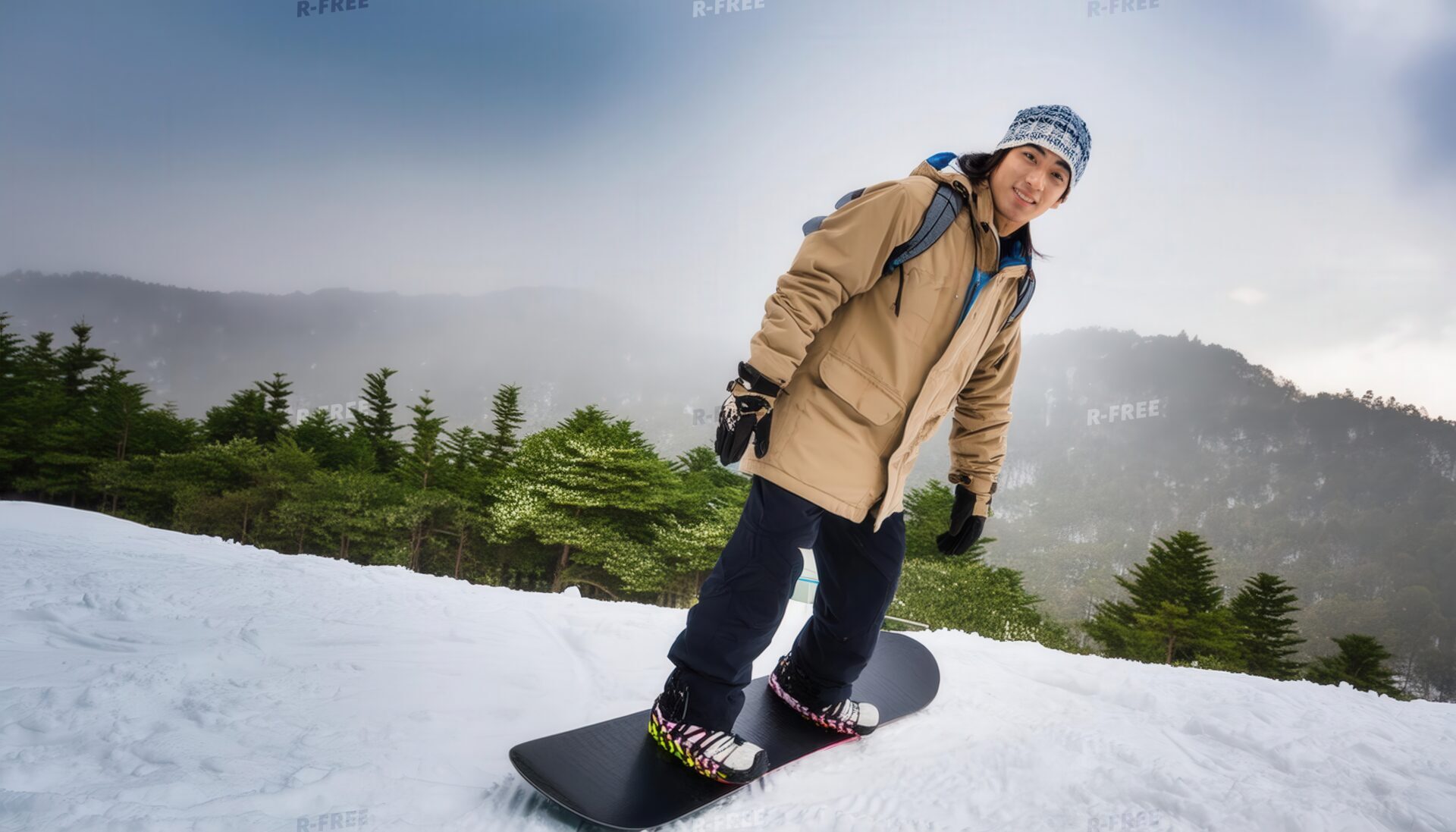 雪山でスノーボードをする男性
