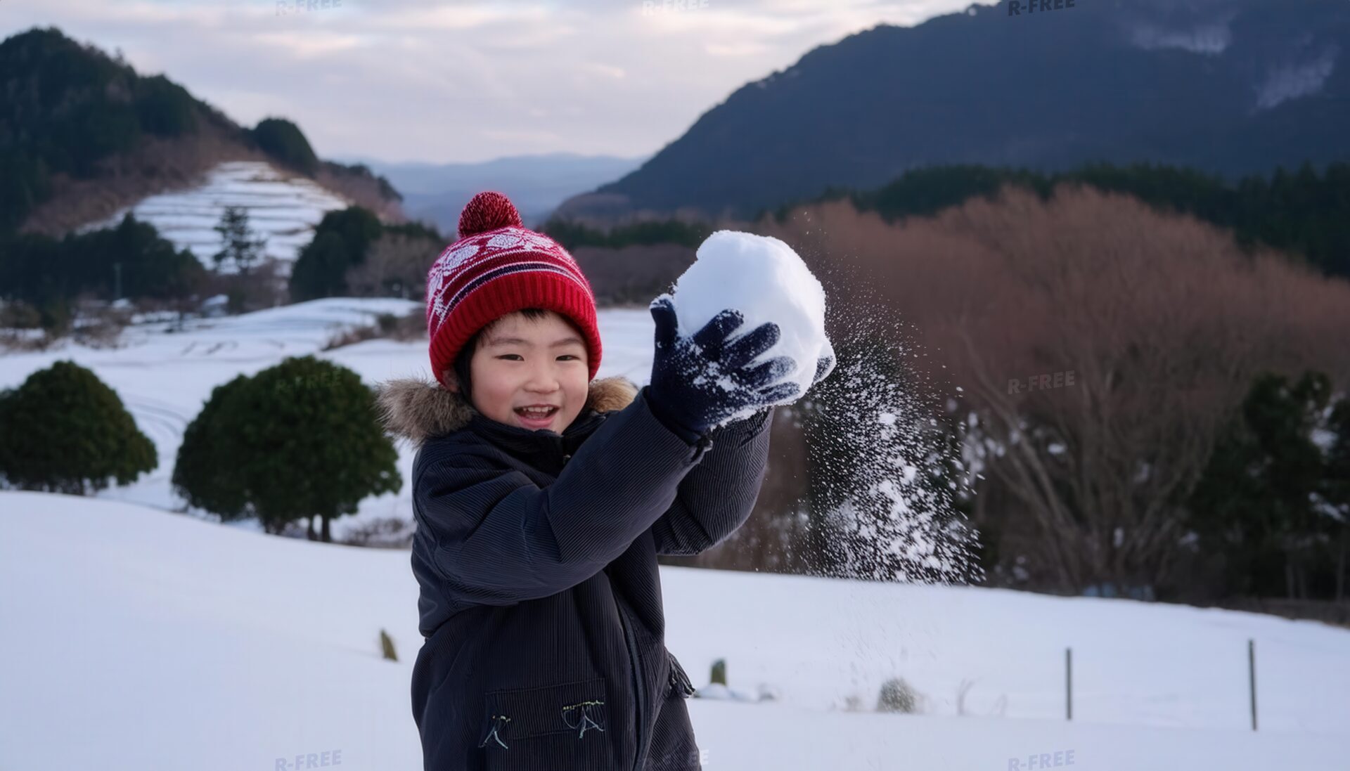 雪玉を投げる笑顔の男の子