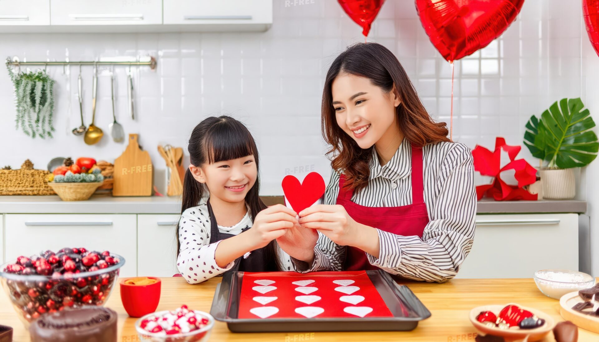 子供と赤いハートの飾りを持つエプロン姿の女性