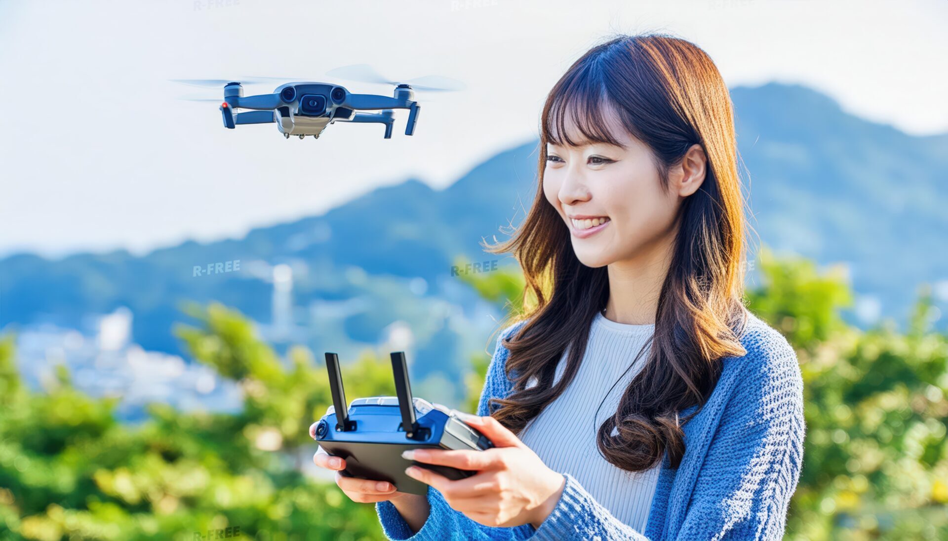 緑豊かな山を背景にドローンを操作する女性