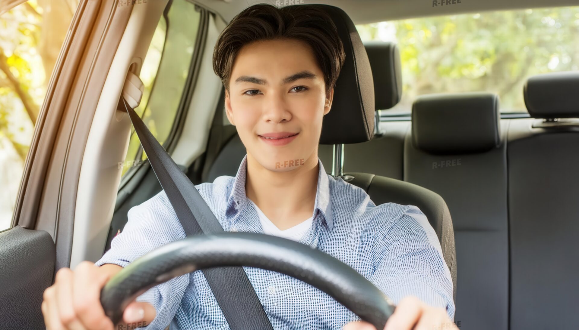 車を運転中の男性（車内・前方を向いて微笑む）