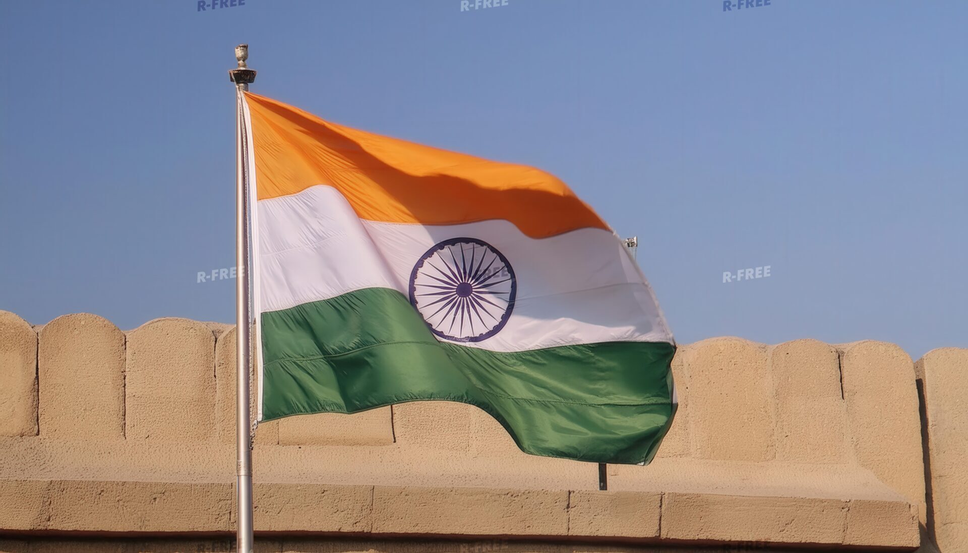 石壁を背景に右へなびくインド国旗