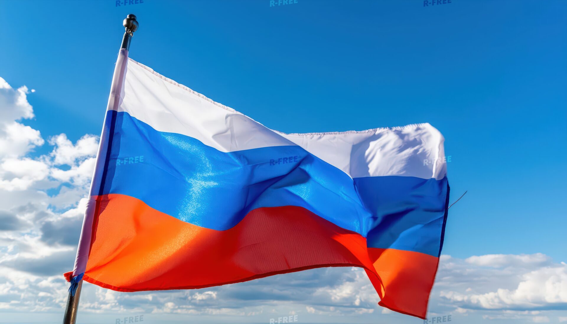 白い雲が浮かぶ青空で風になびくロシア国旗