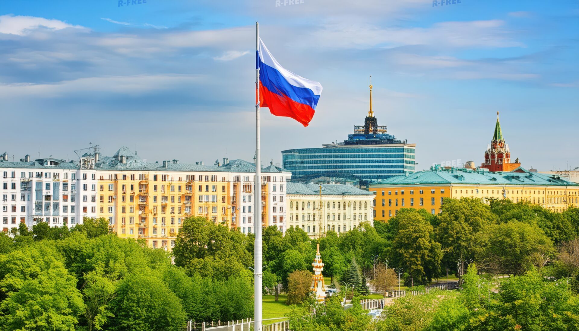 青空になびくロシア国旗と緑豊かな都市風景