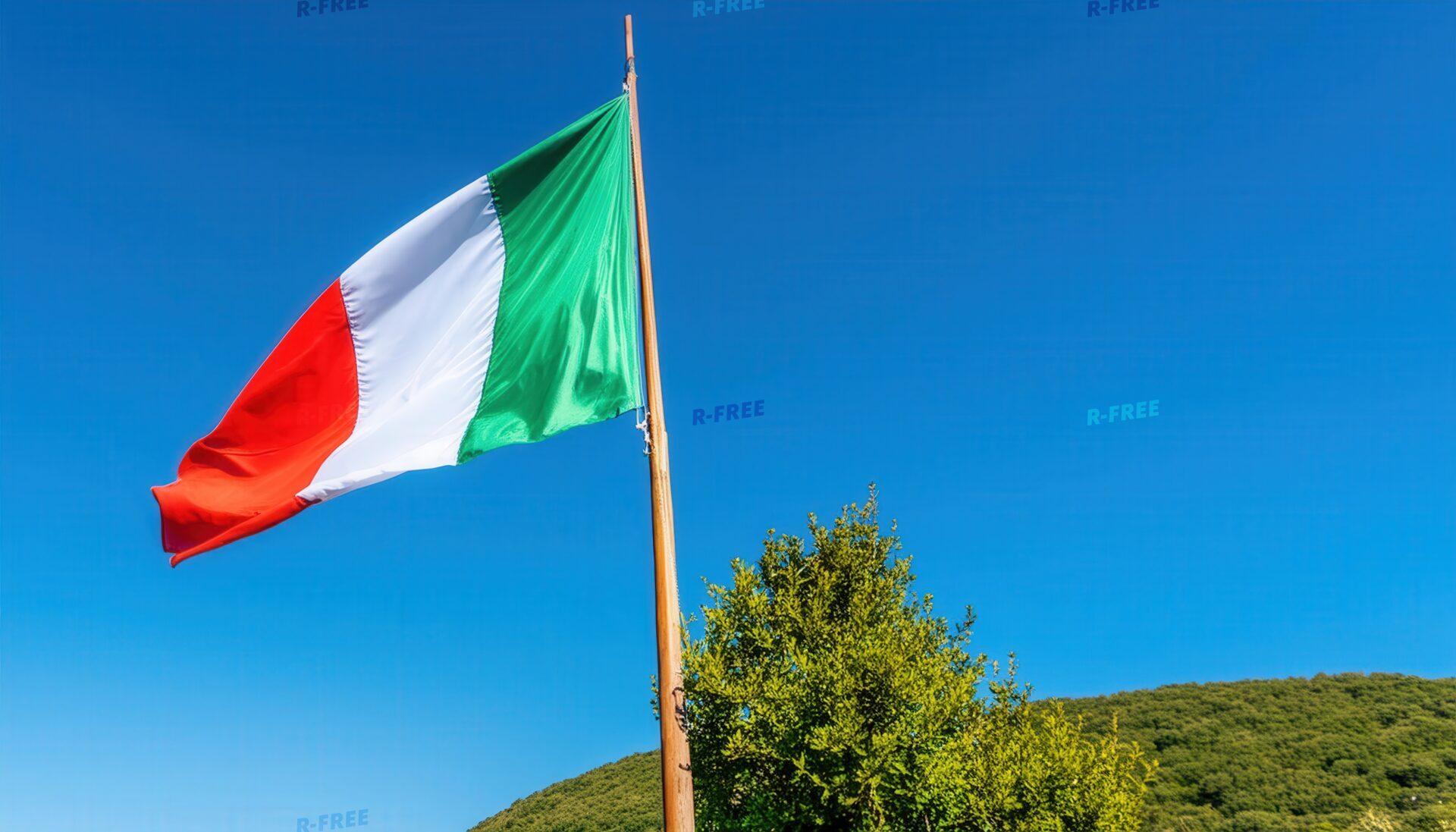 青空を背景に木製ポールで風になびくイタリア国旗