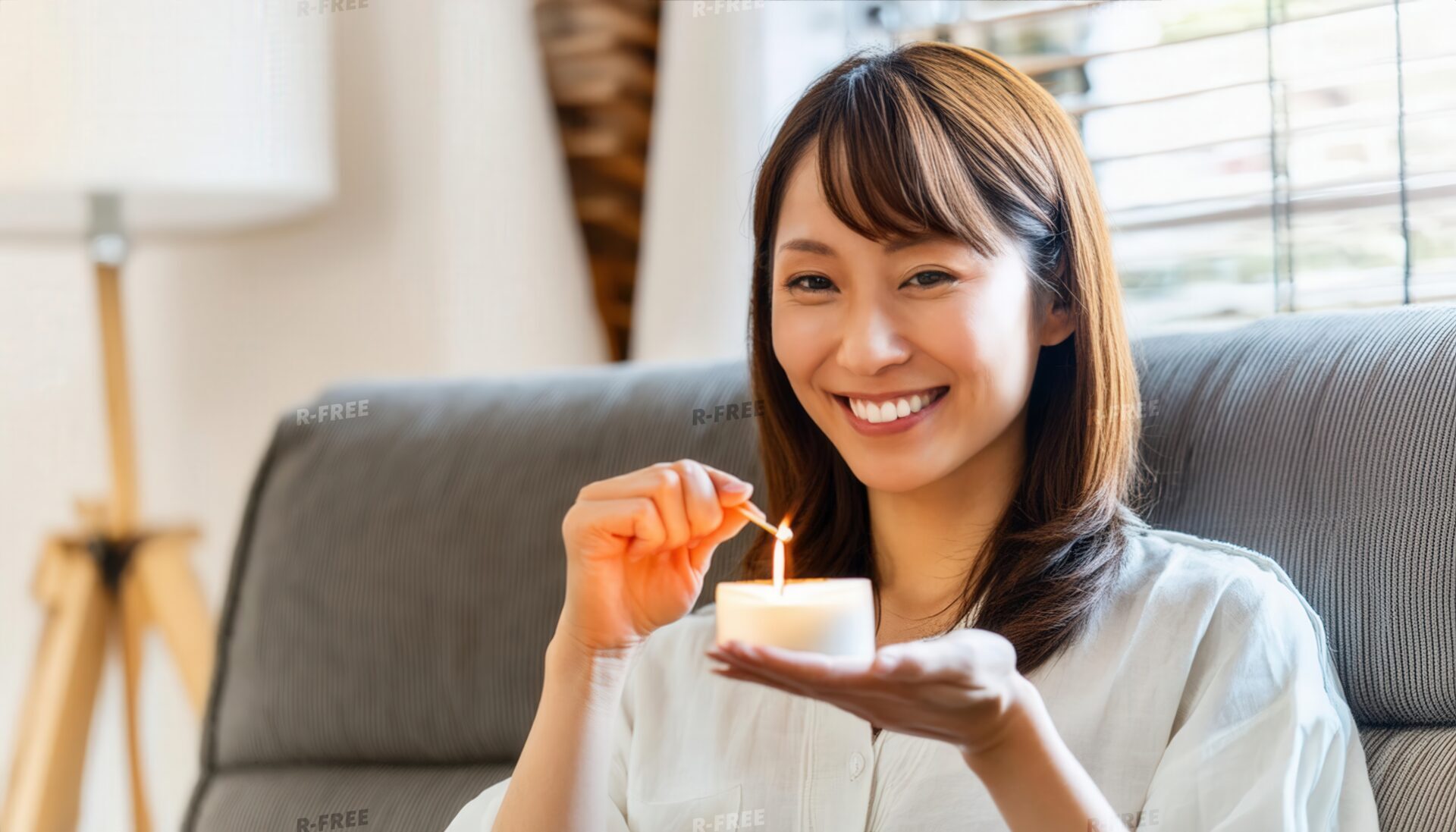 アロマキャンドルを灯す笑顔の女性