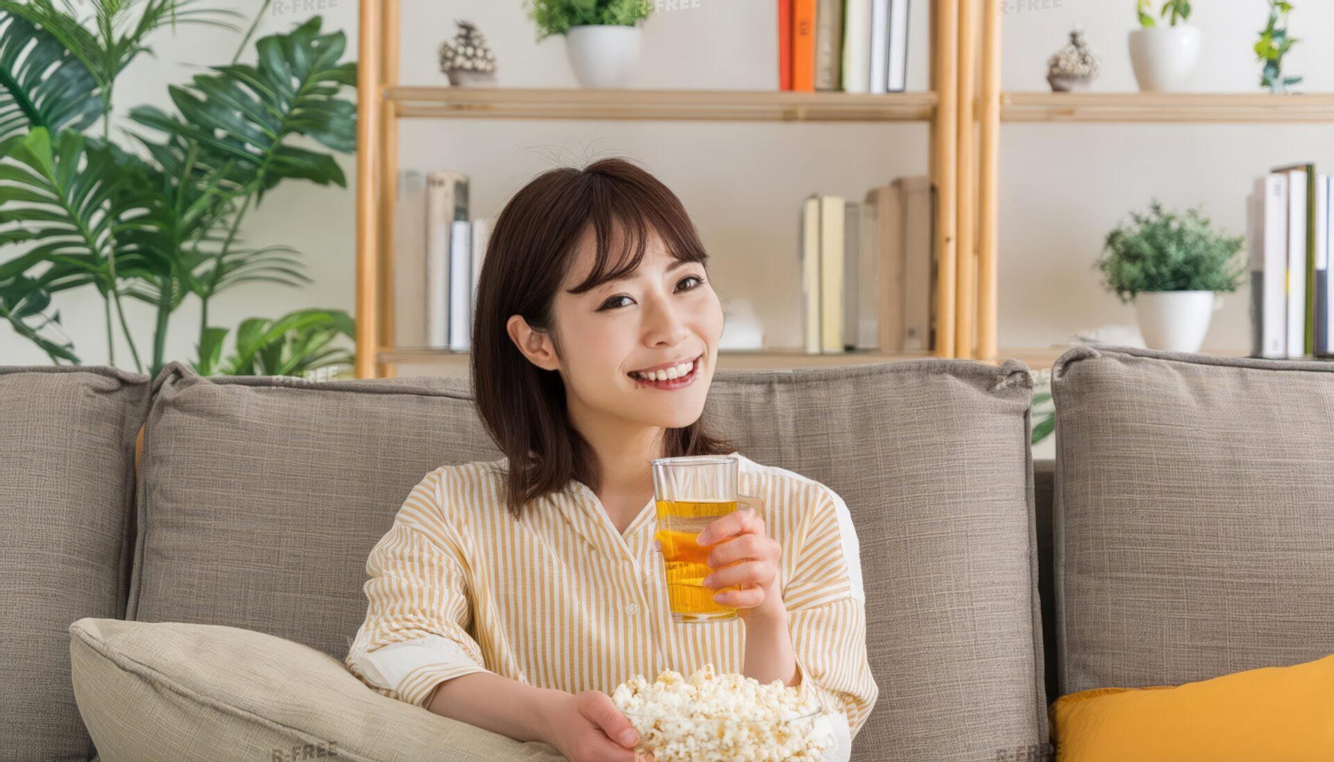 ドリンクとポップコーンを持つ女性