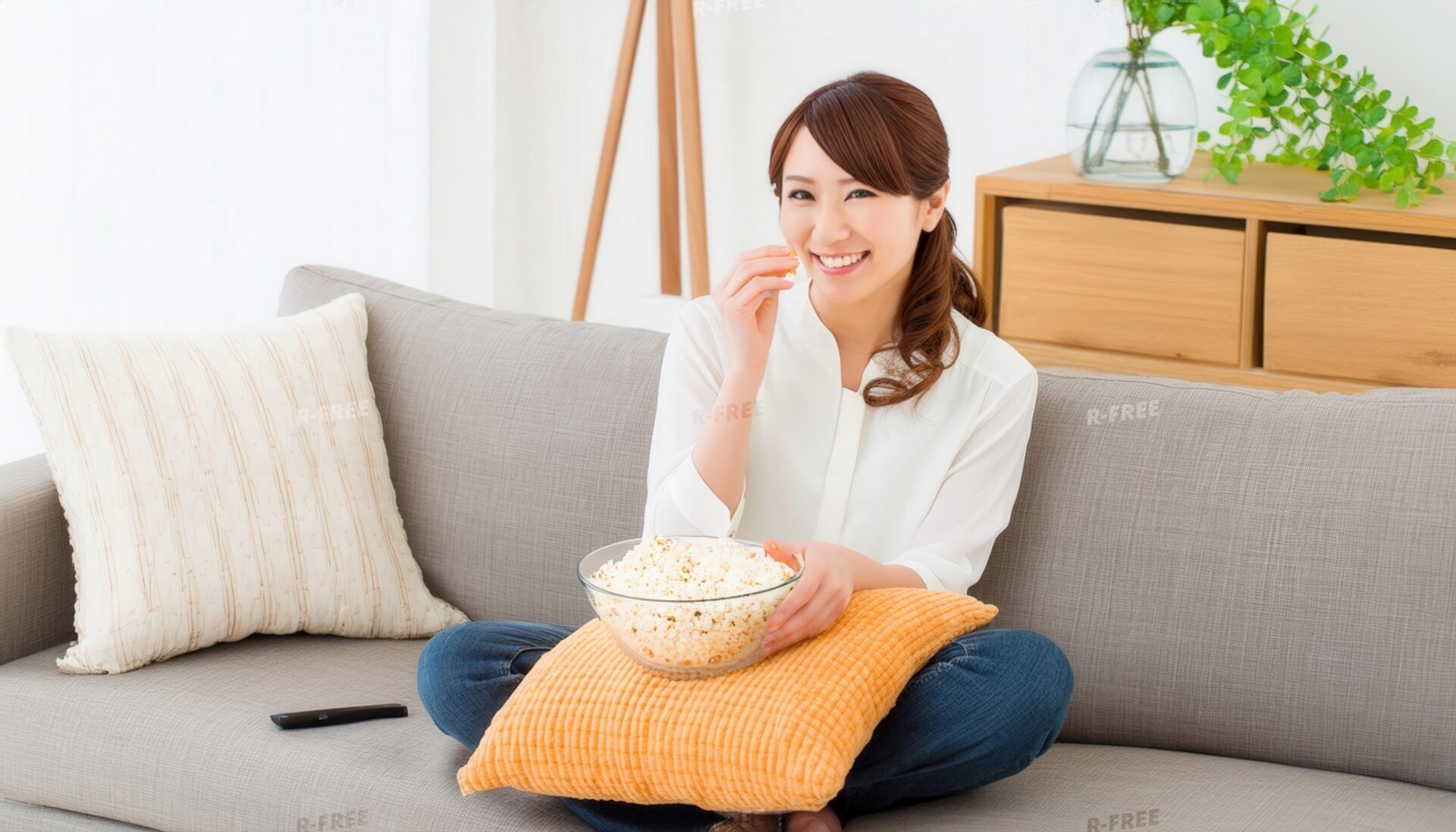 ポップコーンを食べながらくつろぐ女性