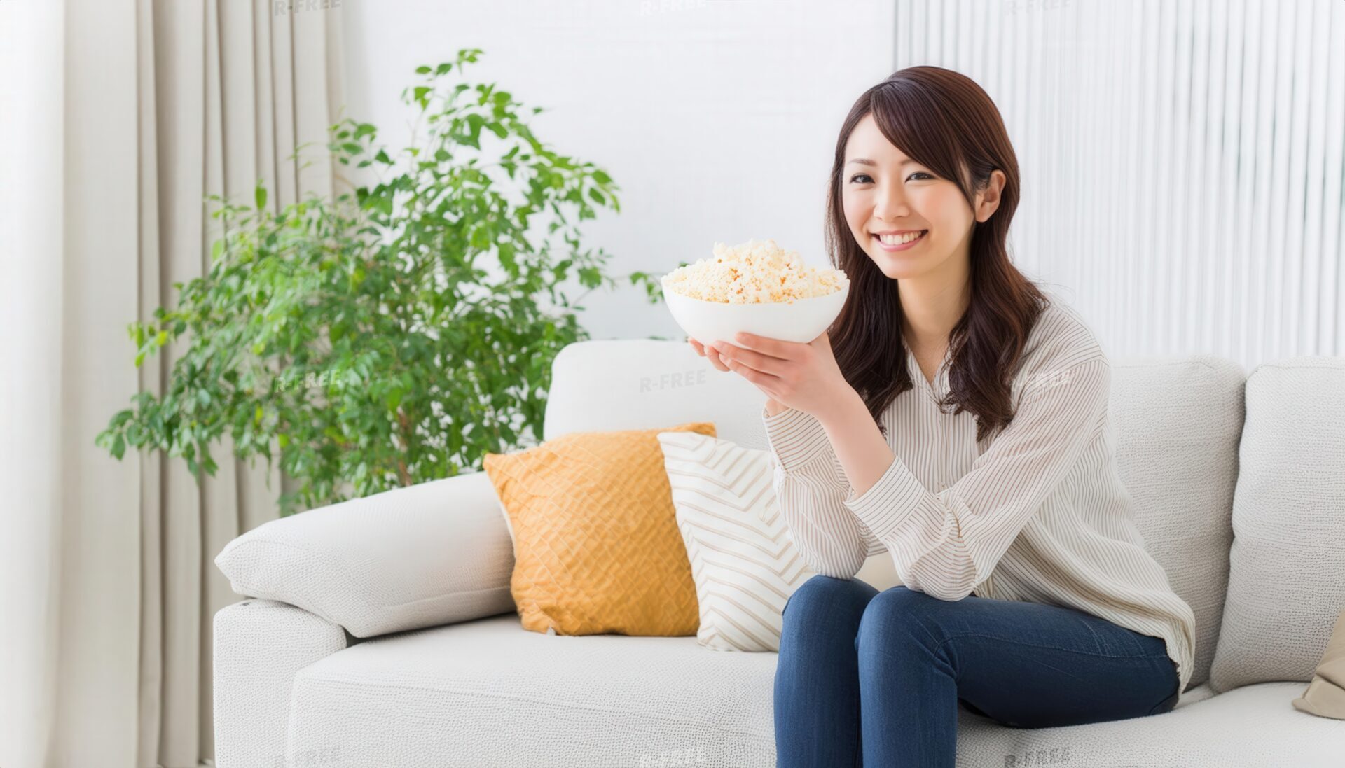 カメラに微笑みポップコーンを手に持つ30代女性