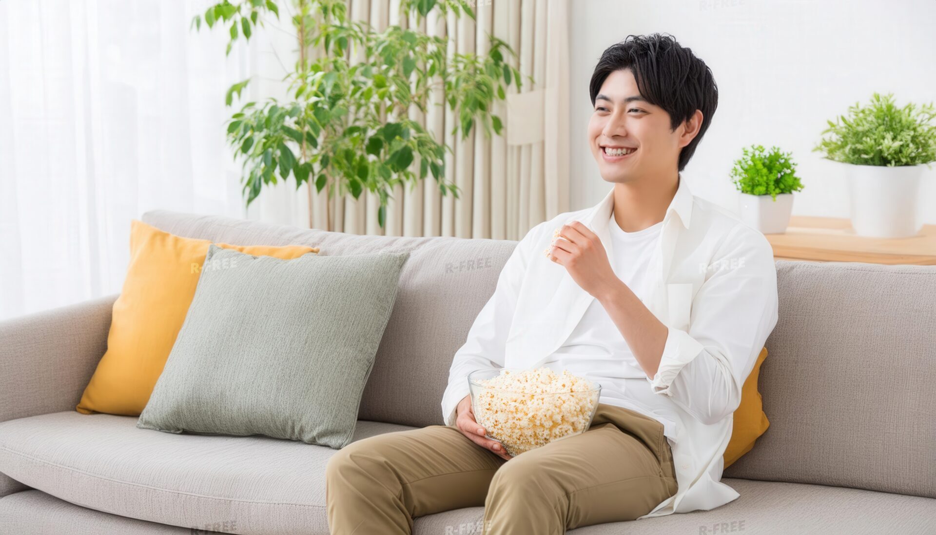 ポップコーンを食べながら笑う男性