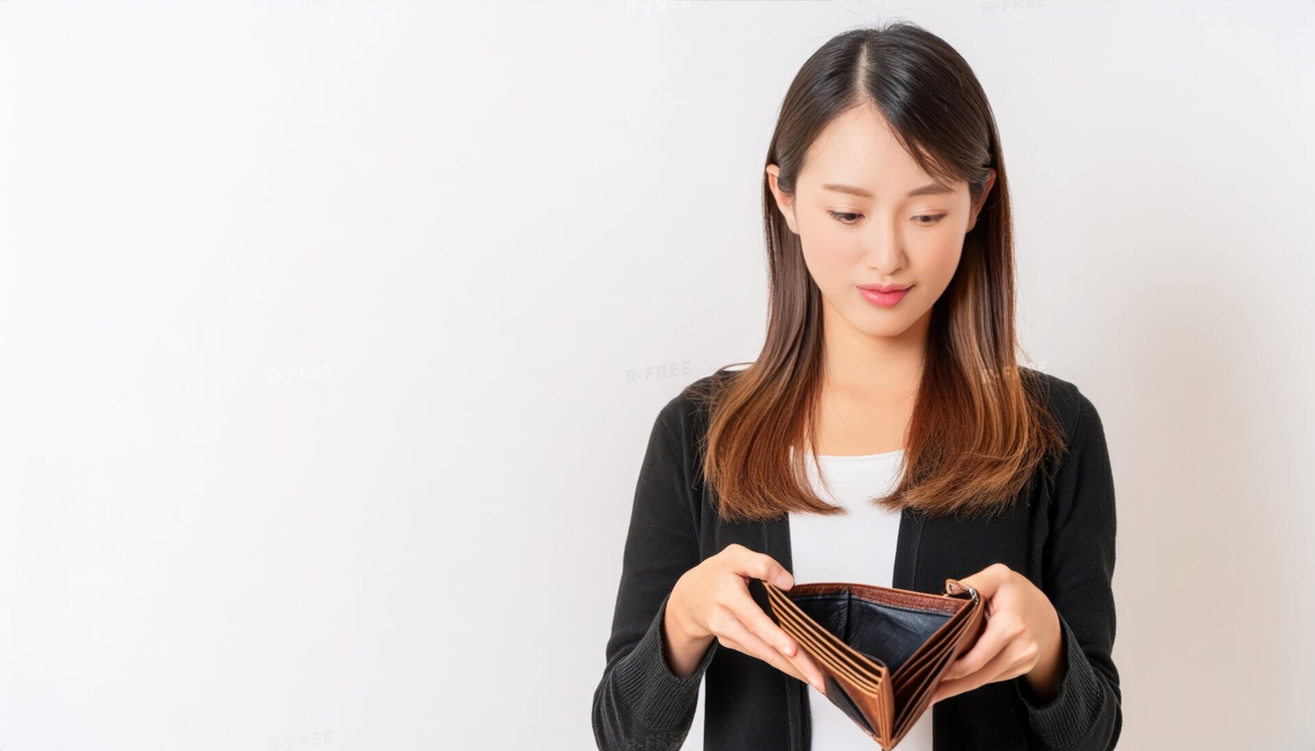 困った表情で空の財布を覗き込む若い女性