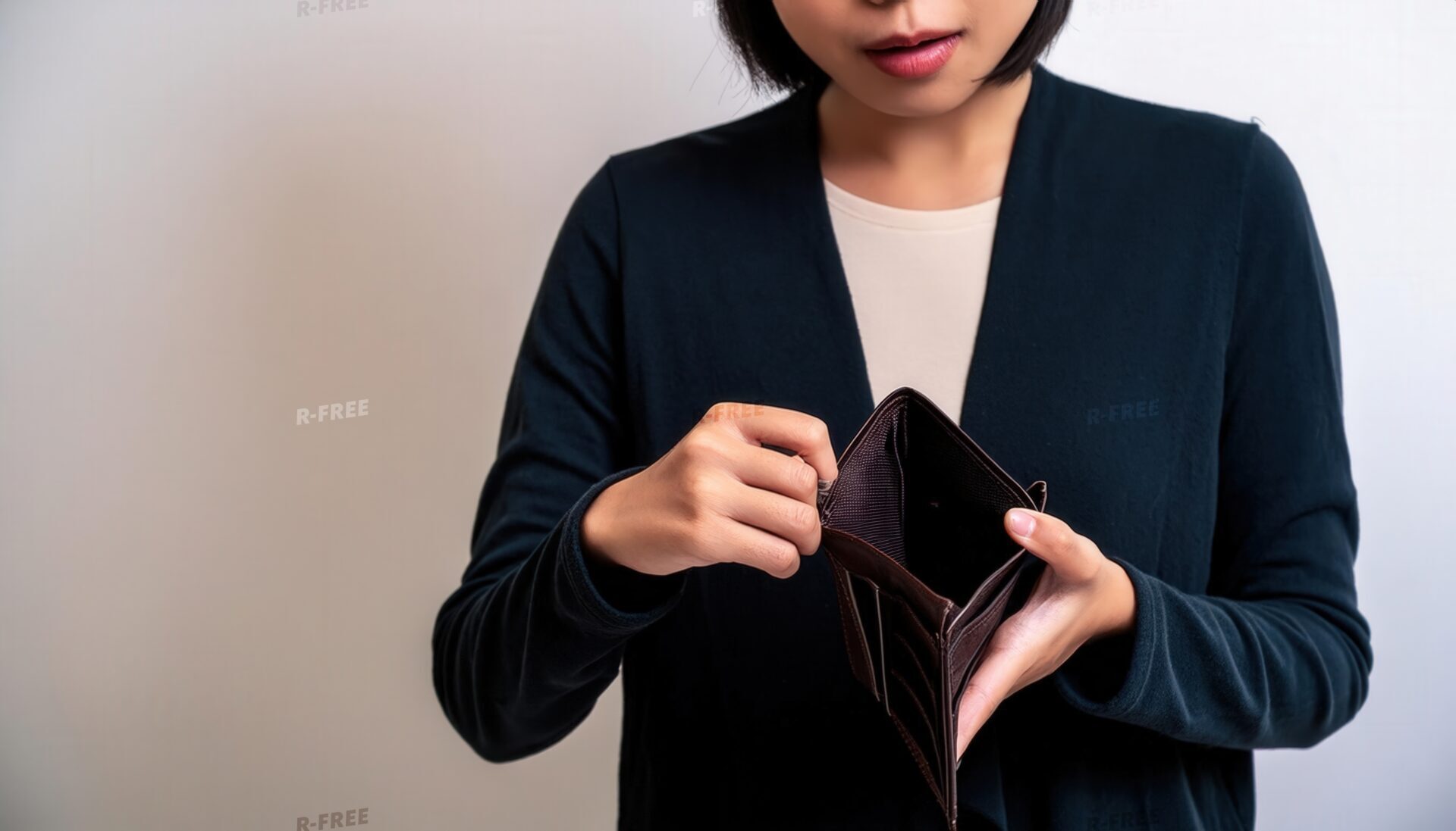 伏し目がちに空の財布を覗く若い女性