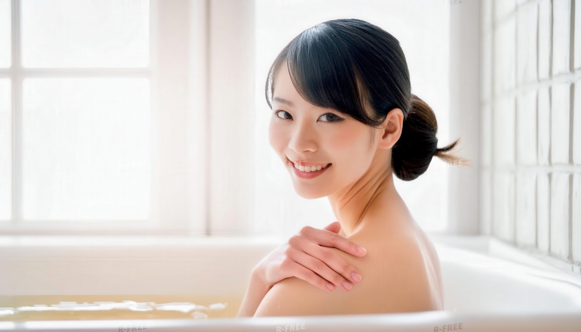 窓から自然光が差す浴室で肩に手を添える女性