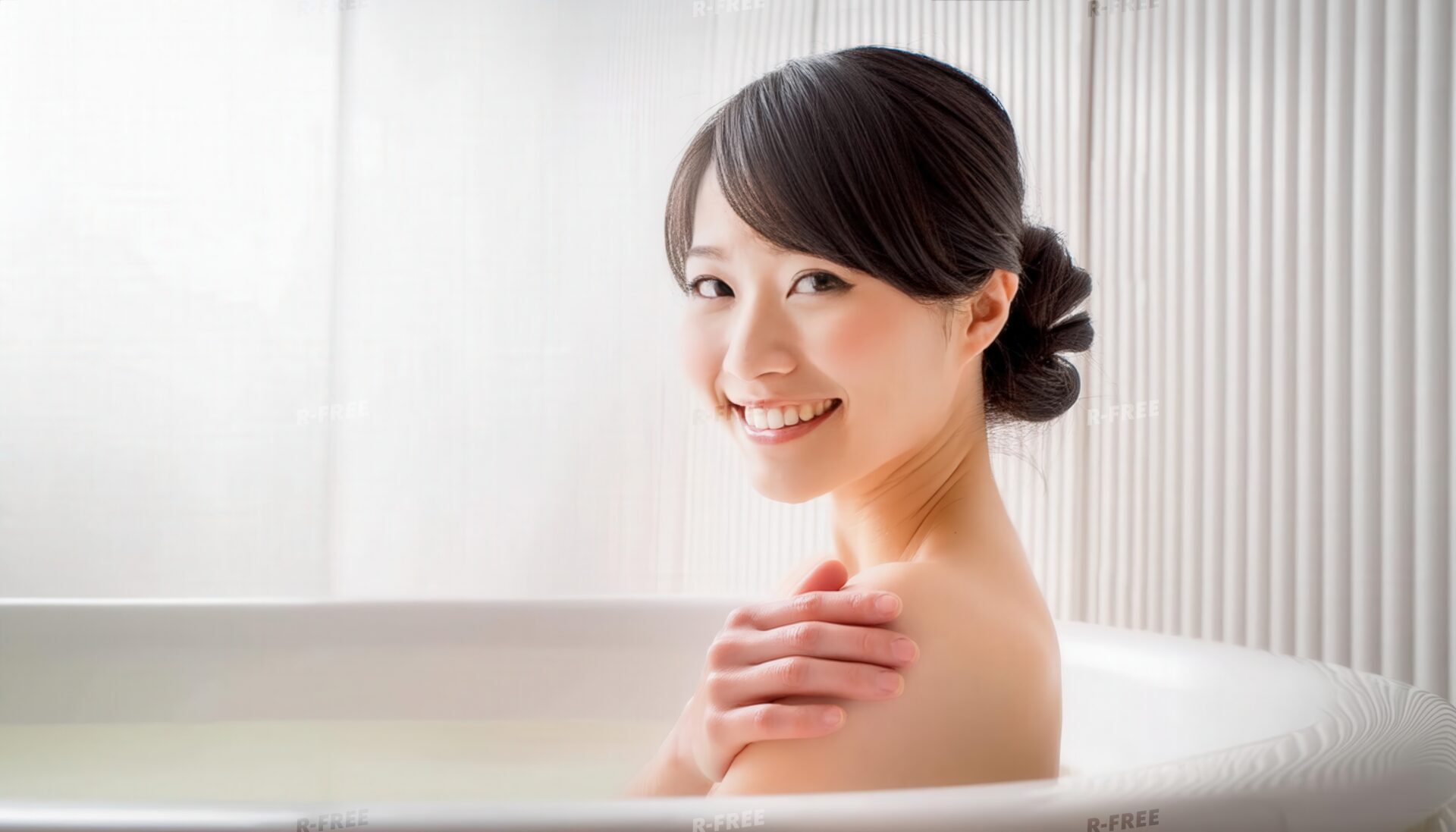 肩に手を置いて微笑むアップヘアの女性