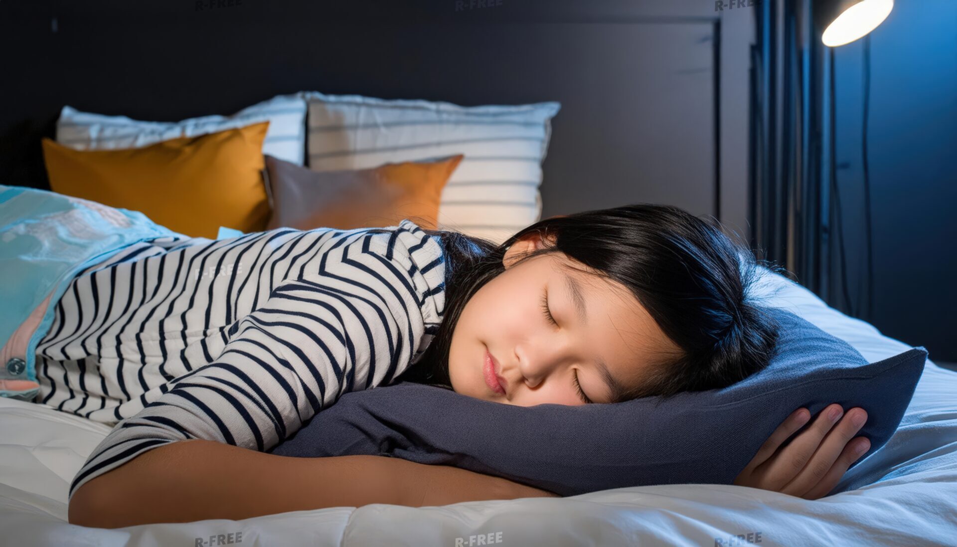 夜に就寝する青い枕のボーダー服の子供