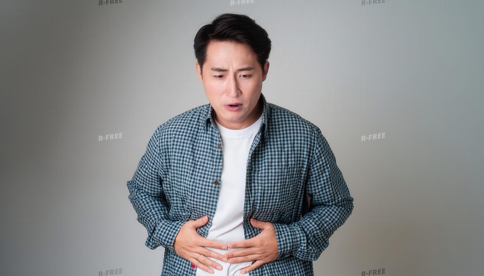 驚いた表情でお腹を押さえる男性