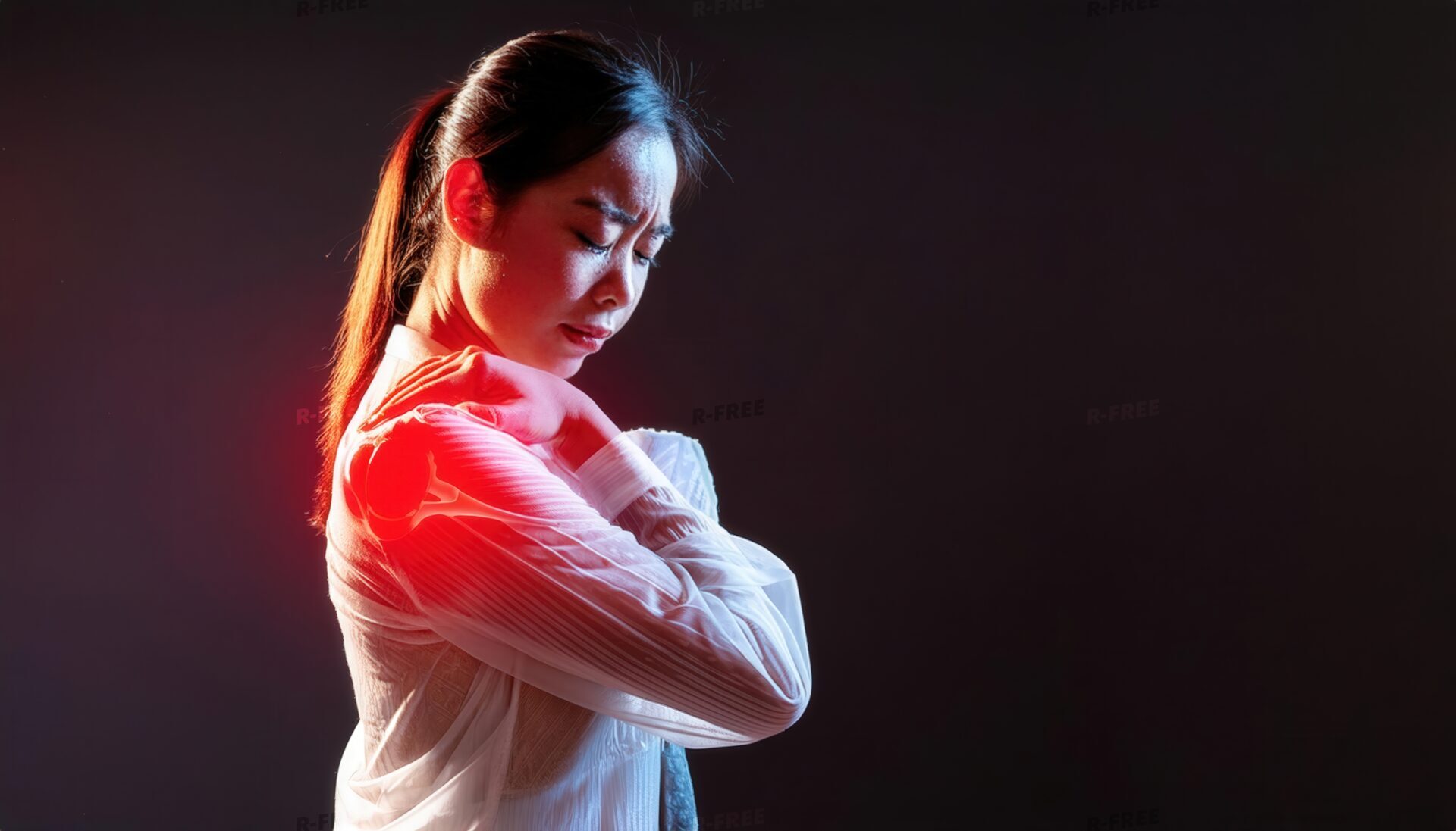 肩こりで赤く発光する肩を掴む白ブラウスの女性