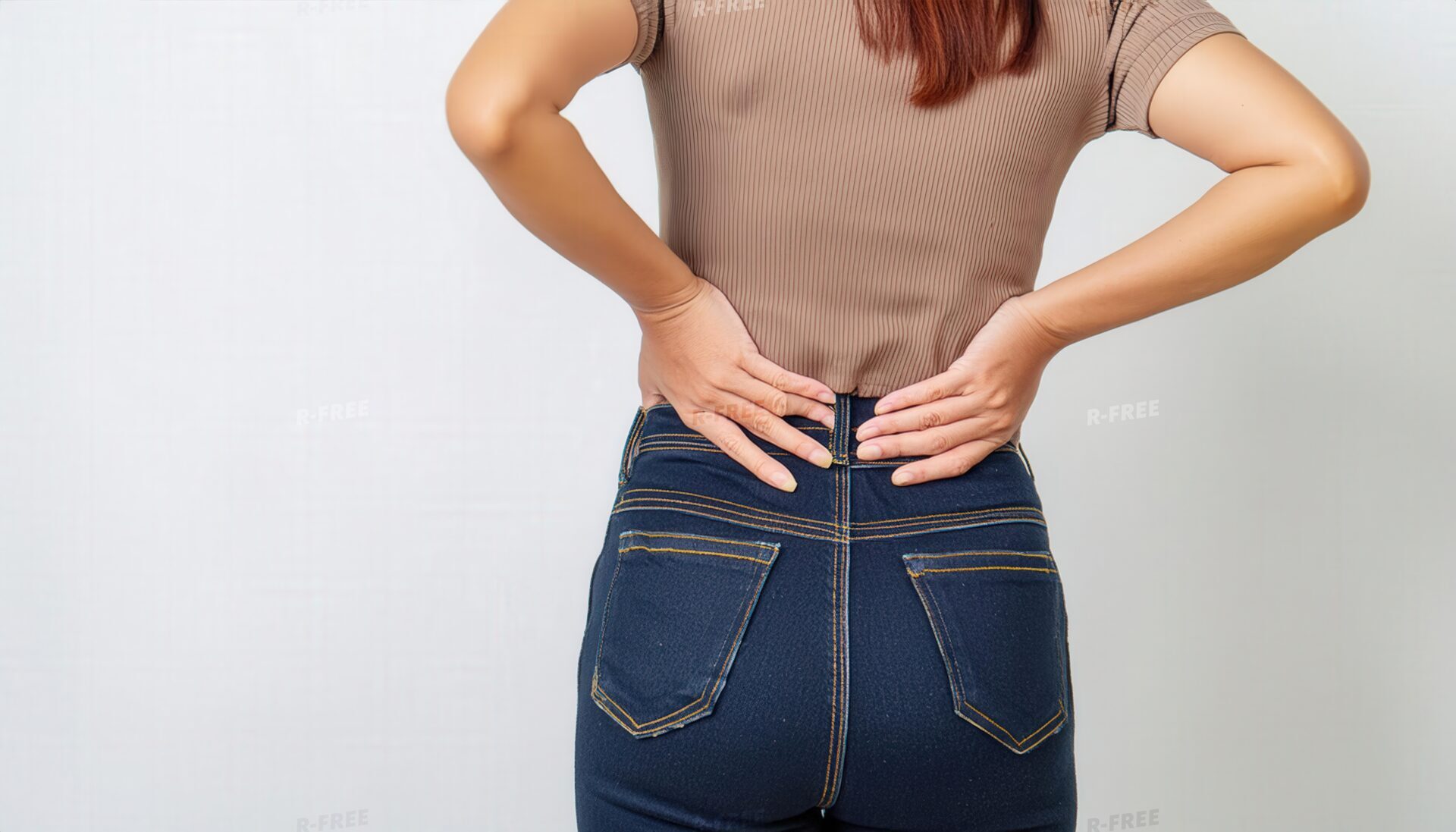 腰を支える茶色の半袖シャツ姿の女性の後ろ姿