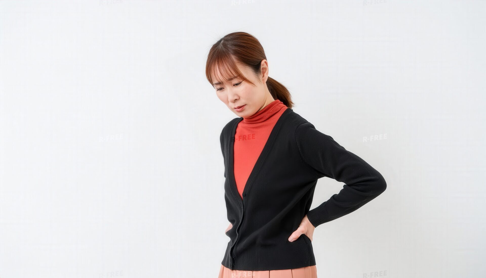 腰を押さえる女性の横顔