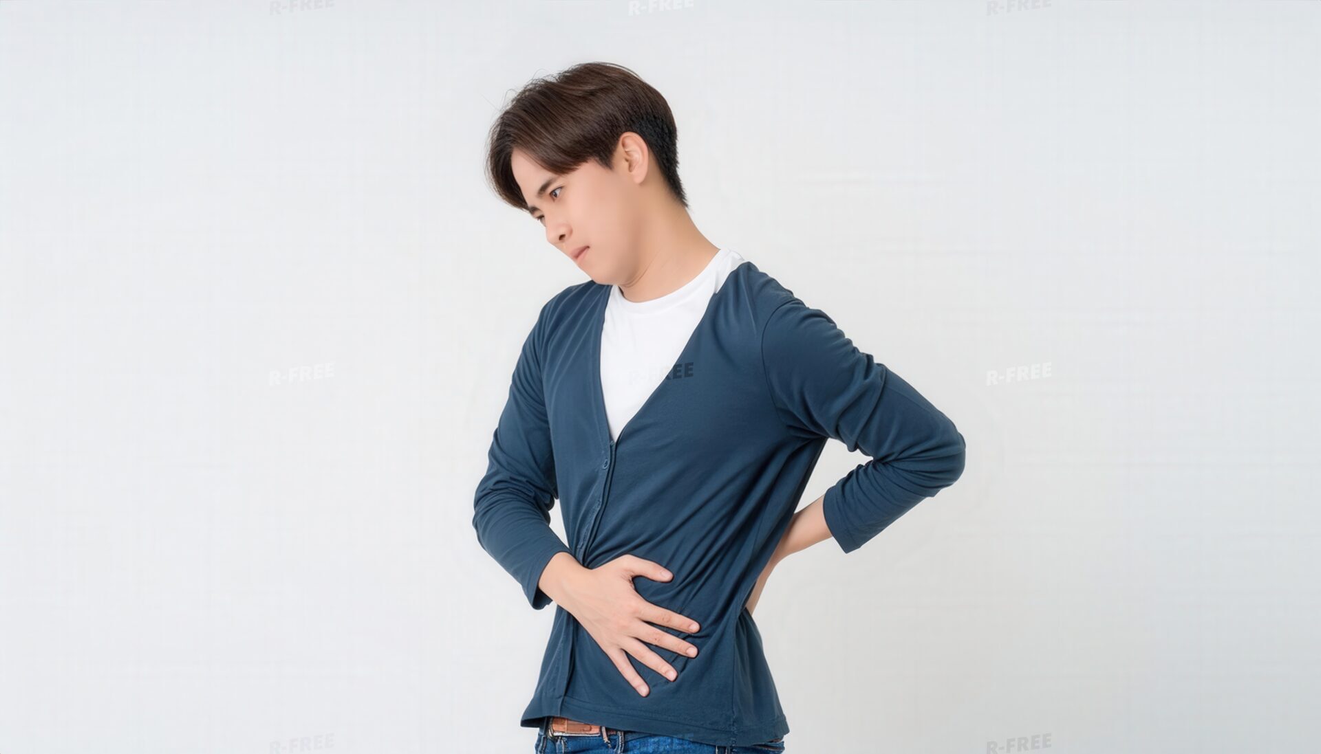 苦悶の表情で腰を押さえる青いカーディガンの男性