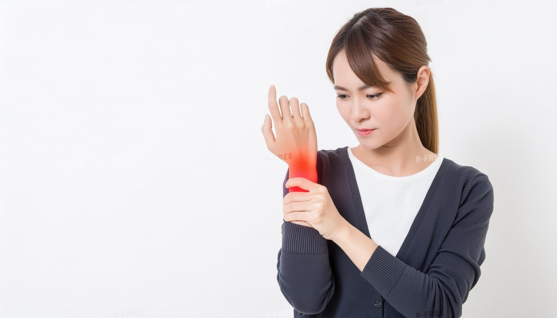 紺色カーディガンで赤く光る右手首を押さえる女性
