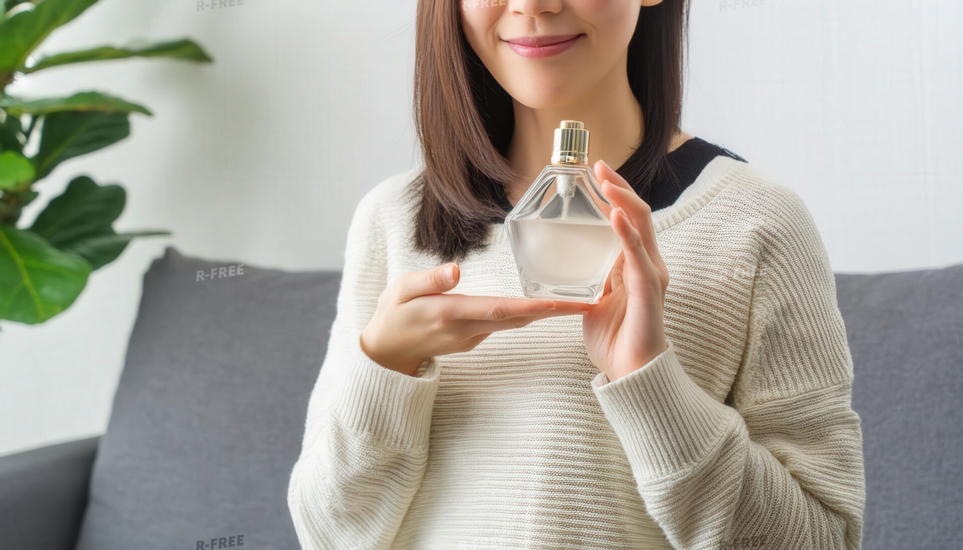 白いリブニット女性が五角形の香水を両手で持つ