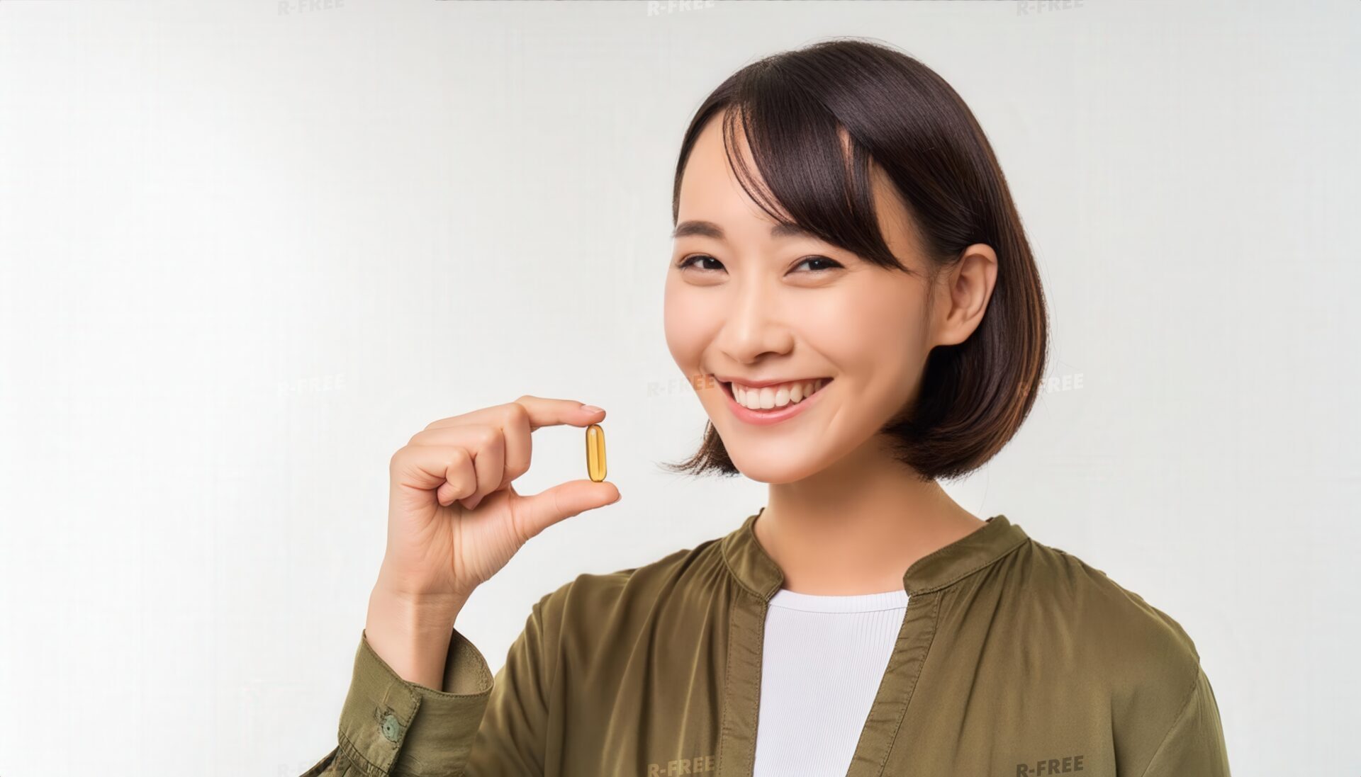オリーブ色の服でカプセルを手にする人物