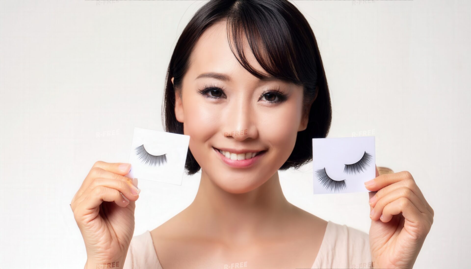 両手につけまつげを示す人物