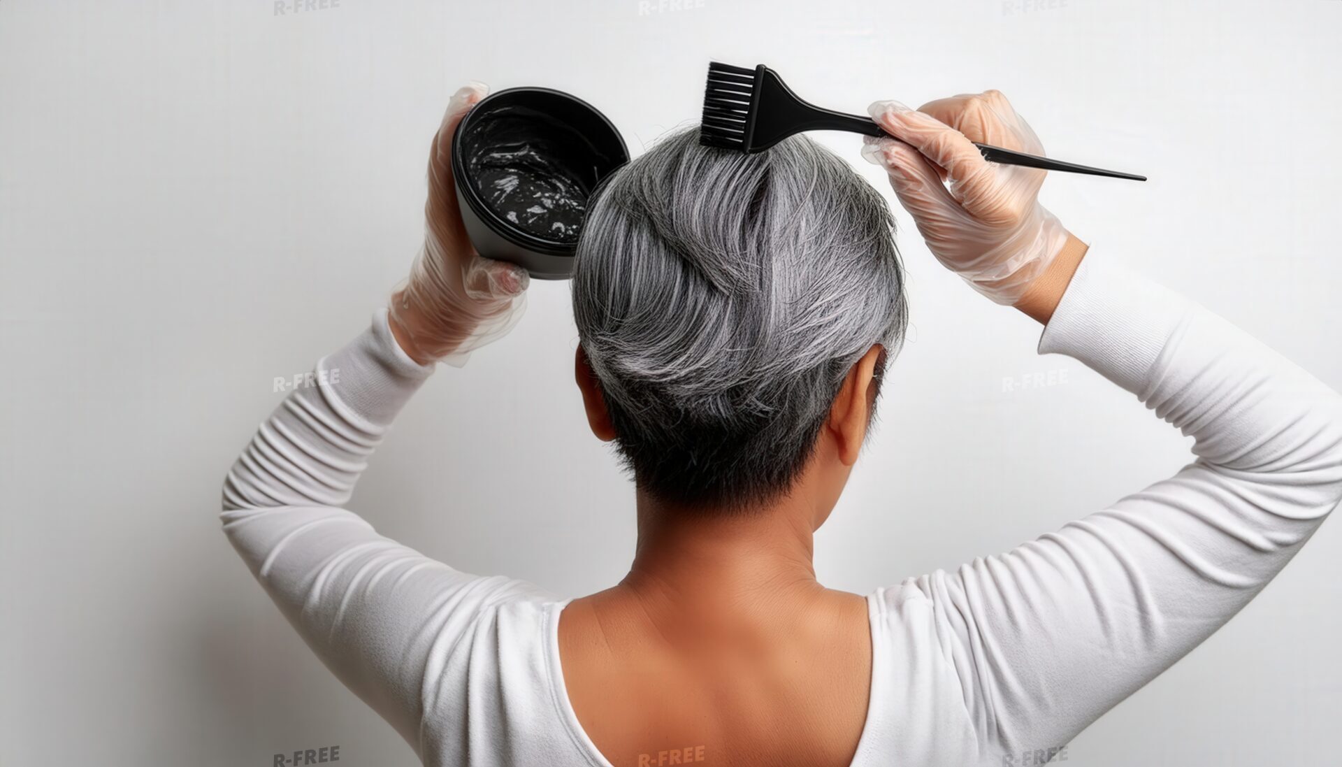 白髪に黒いヘアカラーを塗る後ろ姿