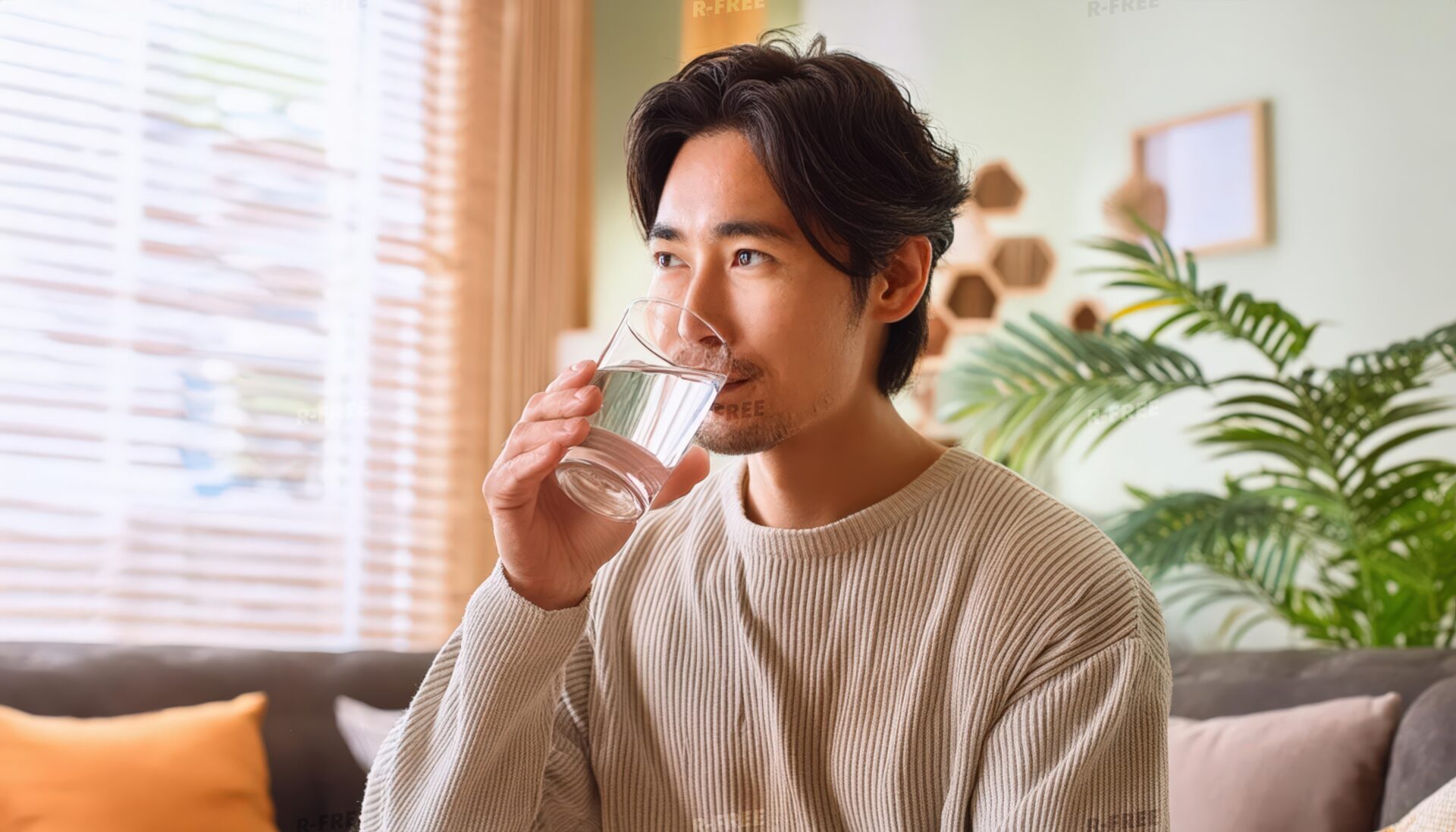 リビングでグラスの水を飲む人（男性）※