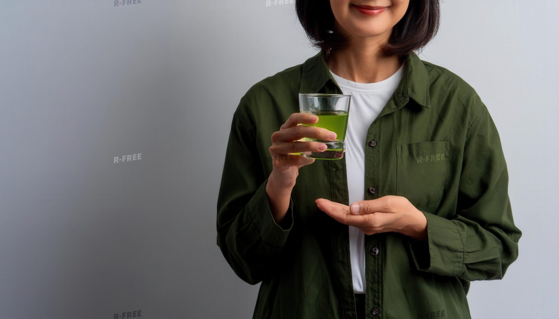 緑茶を手に微笑む緑色シャツの若い女性