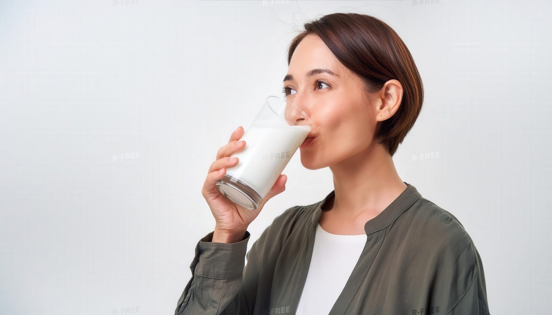 白いシャツとジャケットで牛乳を飲む女性