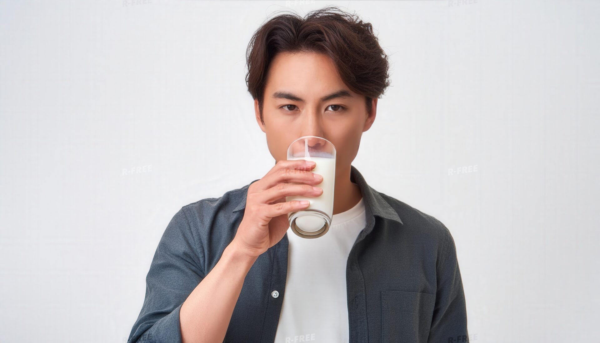 白Tシャツに濃色シャツを重ね牛乳を飲む男性
